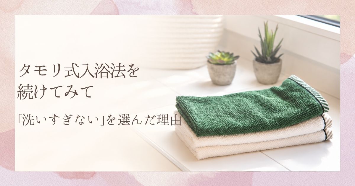 浴室の窓辺に、たたんだタオルと小さな観葉植物が並んでいる様子